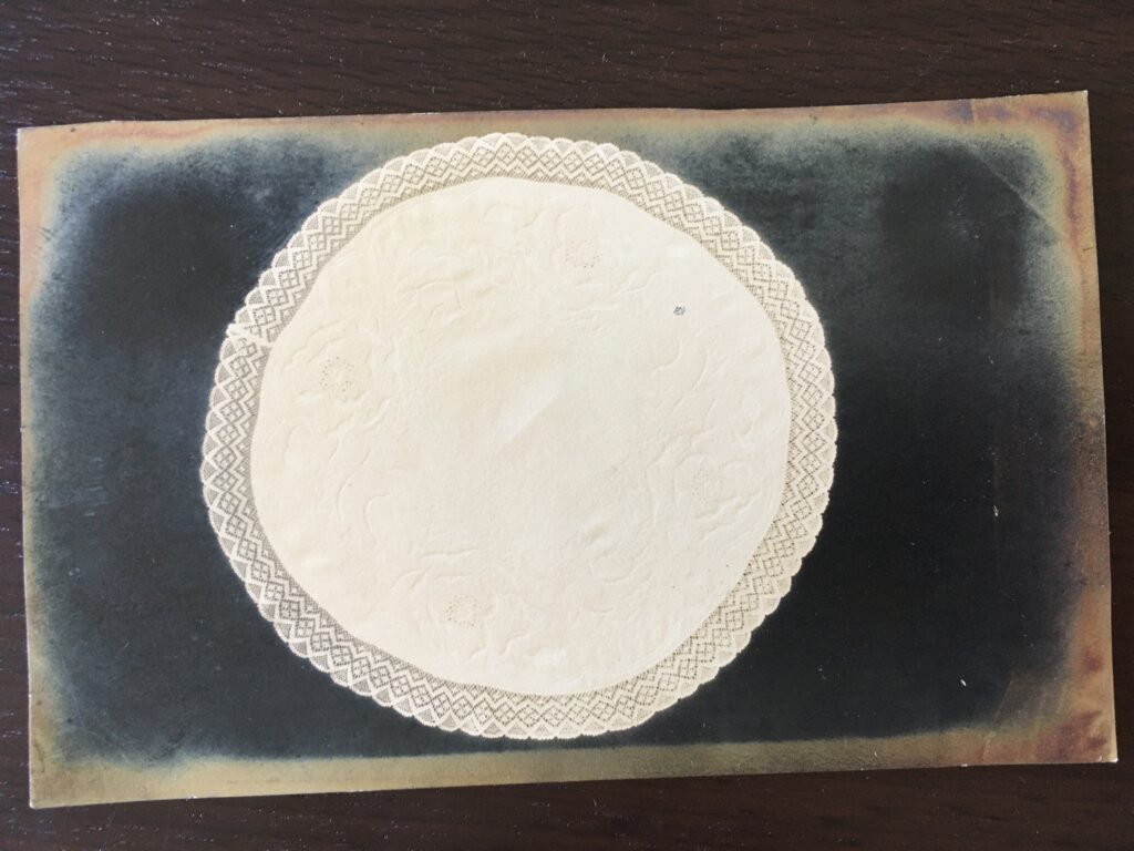 A circular doily with a lace edge.